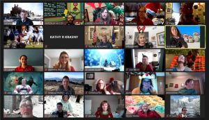 Screenshot of video conference call with many people's faces. Dressed in holiday outfits