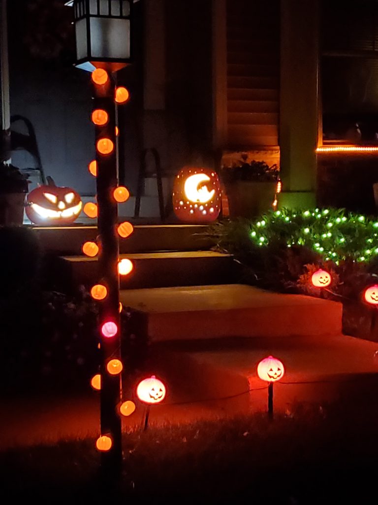 jack-o-lantern pumpkins sitting on a stoop leading up to a porch