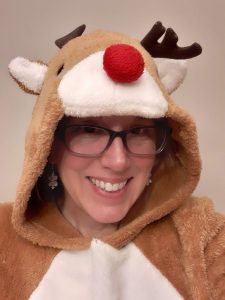 Woman smiling dressed in reindeer hooded costume