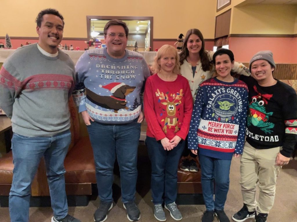 A picture of the HR Holiday Dinner featuring Alex Zewde, Jason Chambers, Rebecca Rohde, Kayla Ruplinger, Cinthya Canicoba, Kong Thao – bonus, Kong made his sweater!